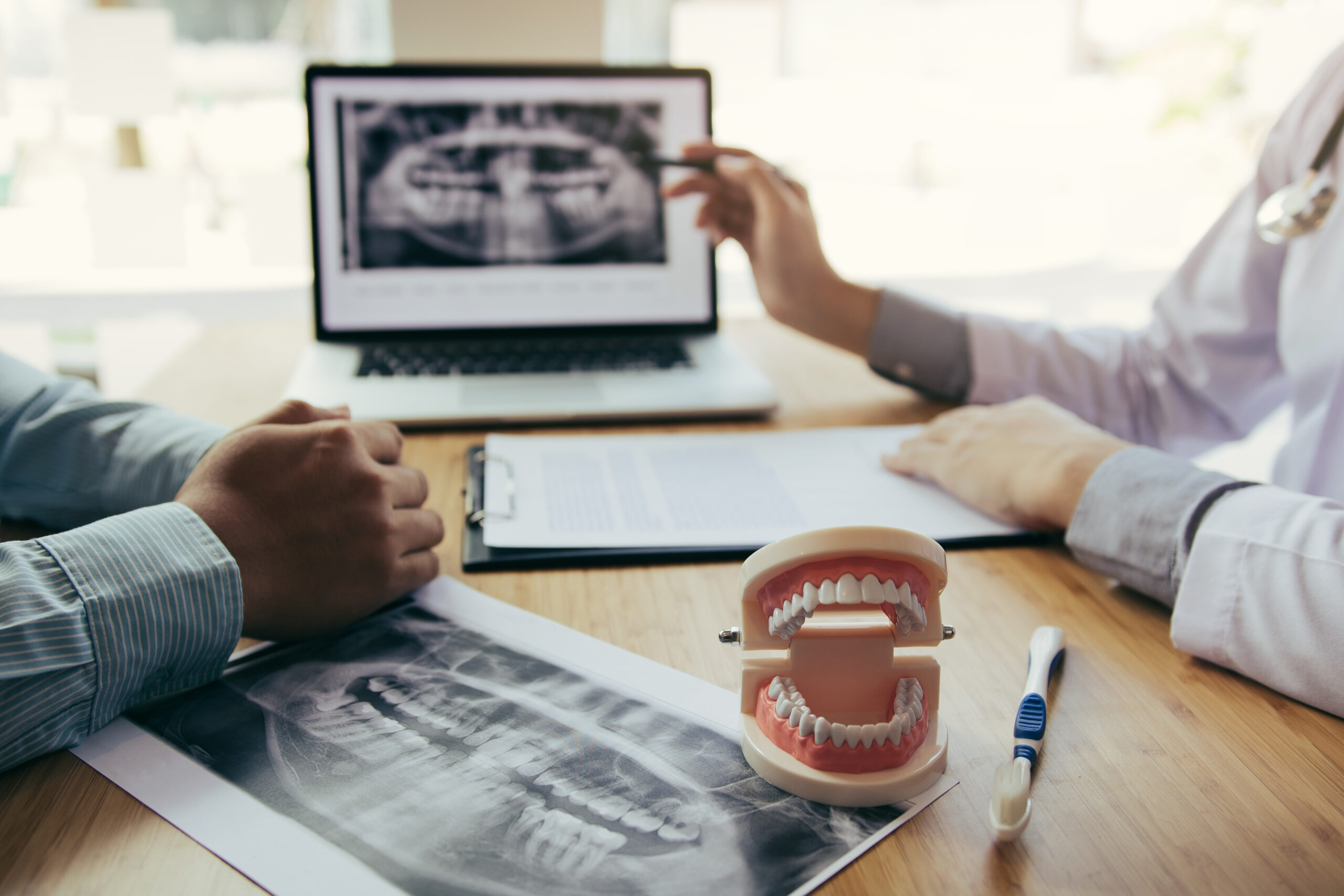 Dental professionals reviewing an x-ray with a patient during an oral surgery consultation