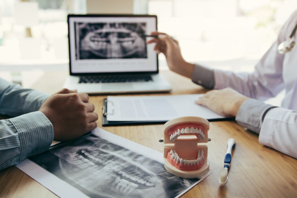 Dental professionals reviewing an x-ray with a patient during an oral surgery consultation