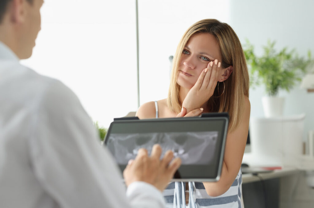 Female patient with acute toothache at doctor appointment with X-ray image. Removal of inflamed teeth concept